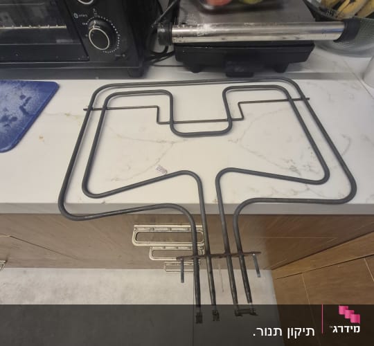 גוף חימום מתכת מונח על משטח מטבח